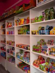 Étagère de la boutique Candy world, remplie de bonbons, boisson, chocolat et chips, halal à Bruxelles
