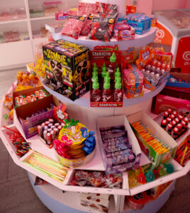 Présentoir circulaire au centre de la boutique, Candy World, garni de bonbons, chocolat et chewing-gum