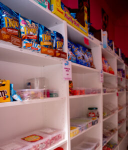 Étagère de la boutique Candy world, remplie de bonbons, boisson, chocolat et chips, halal à Bruxelles