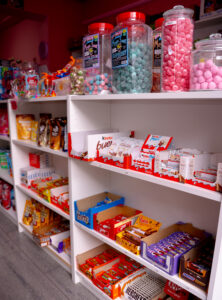 Étagère de la boutique Candy world, remplie de bonbons, boisson, chocolat et chips, halal à Bruxelles
