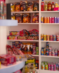 Étagère de la boutique Candy world, remplie de bonbons, boisson, chocolat et chips, halal à Bruxelles