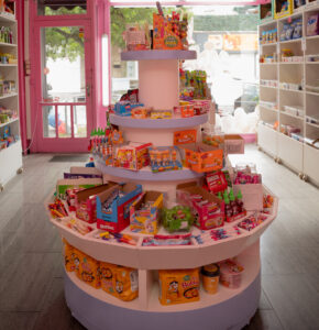 Présentoir circulaire au centre de la boutique, Candy World, garni de bonbons, chocolat et chewing-gum