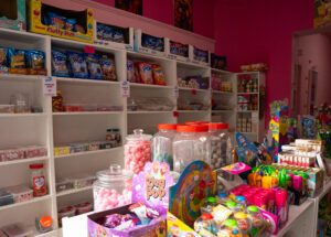 Étagère de la boutique Candy world, remplie de bonbons, boisson, chocolat et chips, halal à Bruxelles