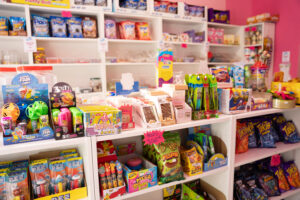 Étagère de la boutique Candy world, remplie de bonbons, boisson, chocolat et chips, halal à Bruxelles